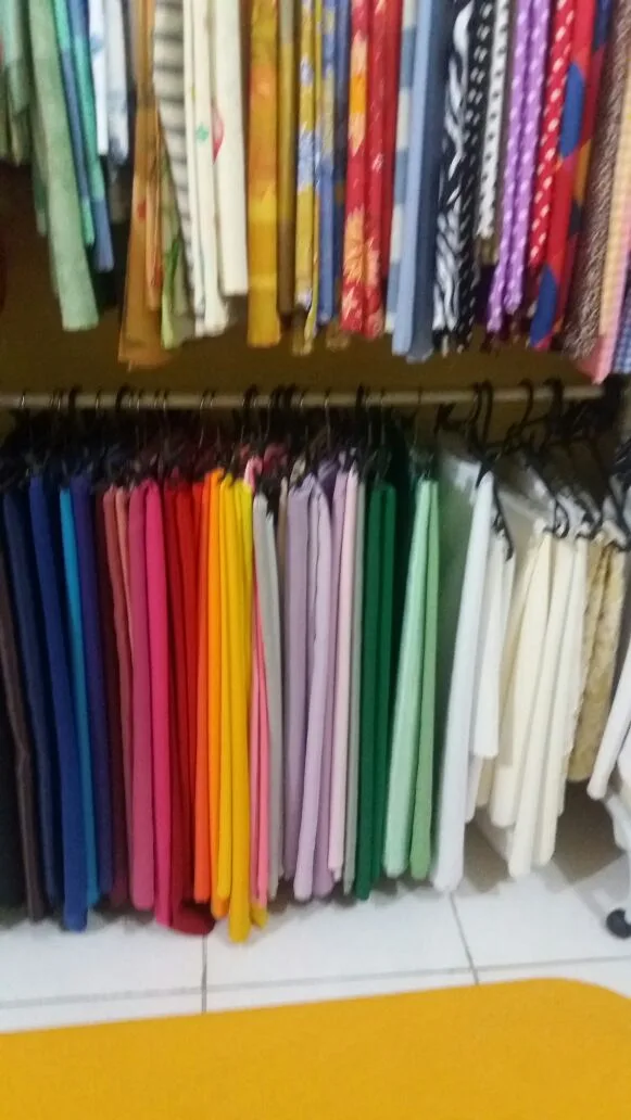 Arara com dezenas de tecidos lisos coloridos na loja